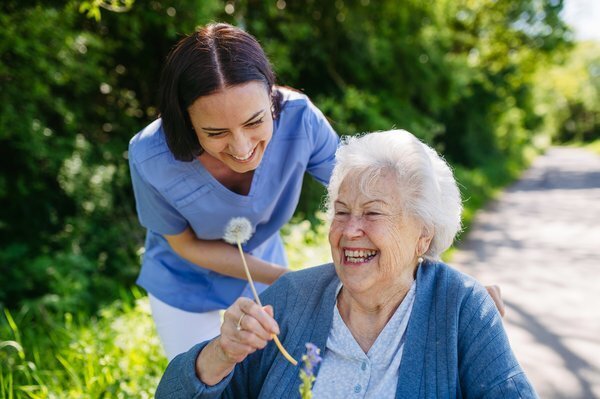 assisted-living-caregiver-elderly-woman-outdoor-care